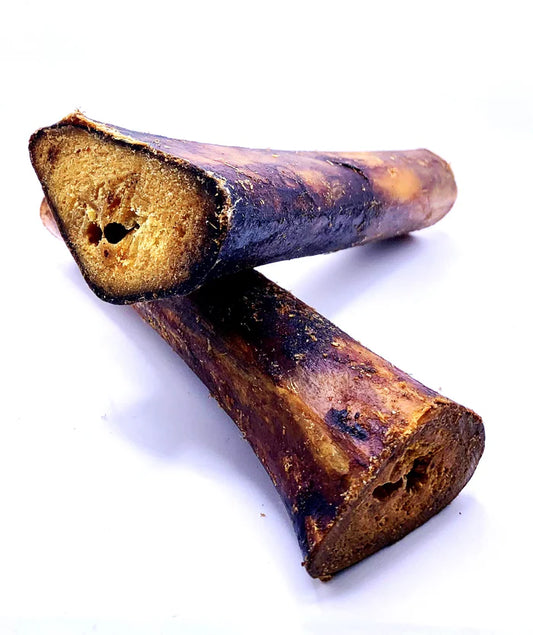 Mabel's Natural Pet Supplies™ ostrich marrow bone dog treat, approximately 18cm long, showing the textured bone and marrow inside.