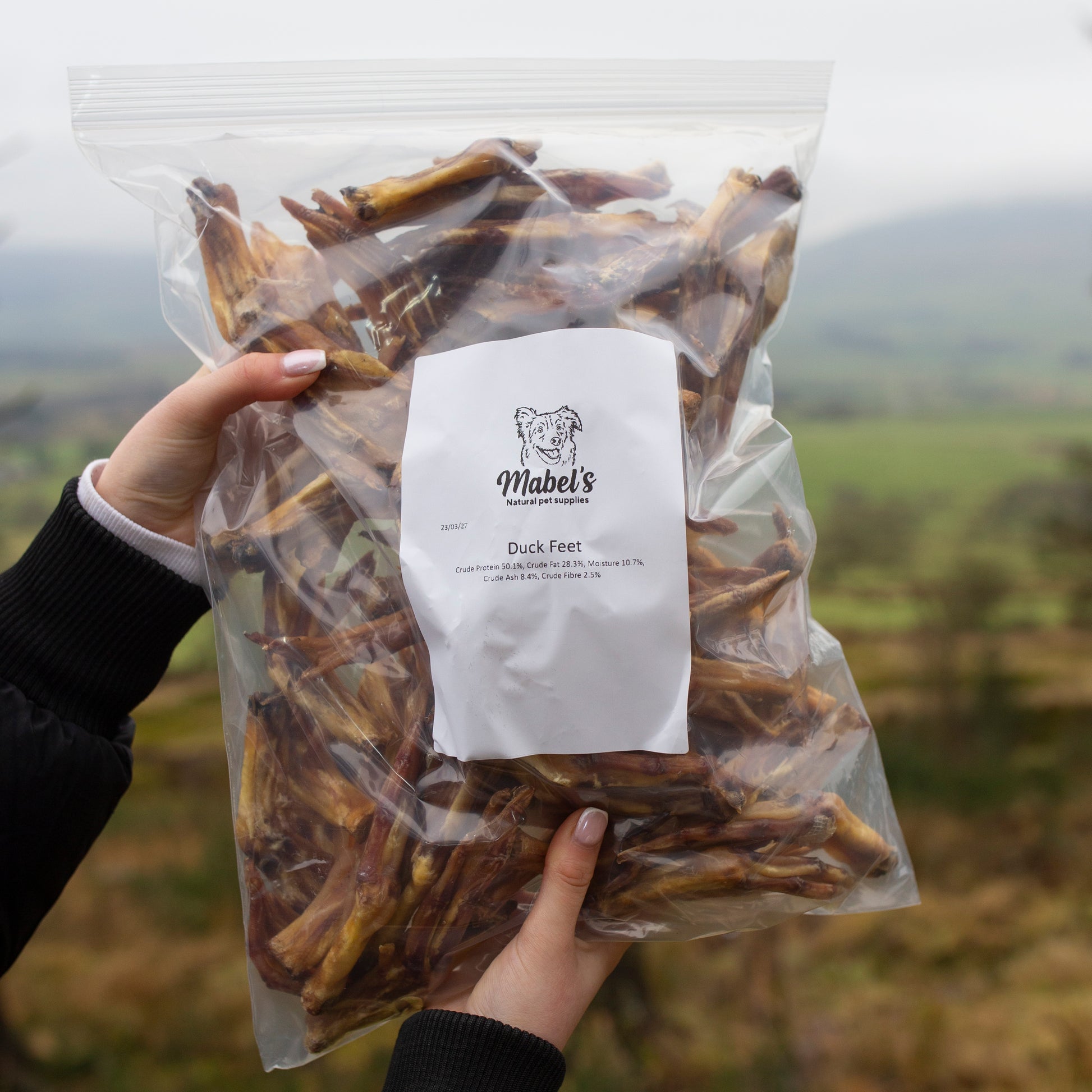 1kg bulk bag of Mabel's Natural Pet Supplies™ duck feet dog treats in a clear plastic bag, showing natural, crunchy dog treats.